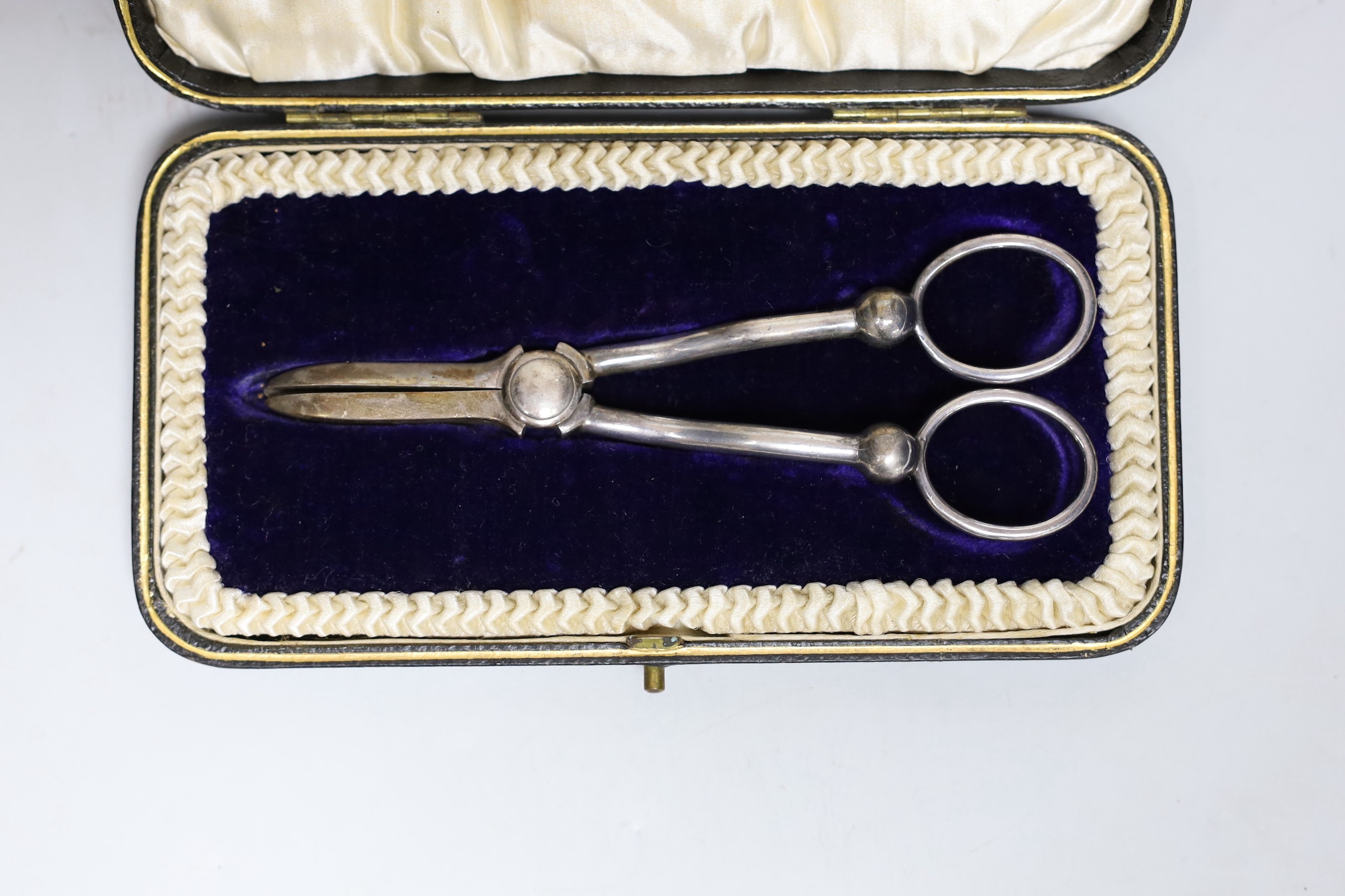 A cased set of Edwardian silver grape shears, Sheffield, 1901 and two other cased sets including cake forks and tea knives.